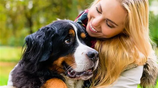 Frau umarmt lächelnd ihren Hund | Aquatop